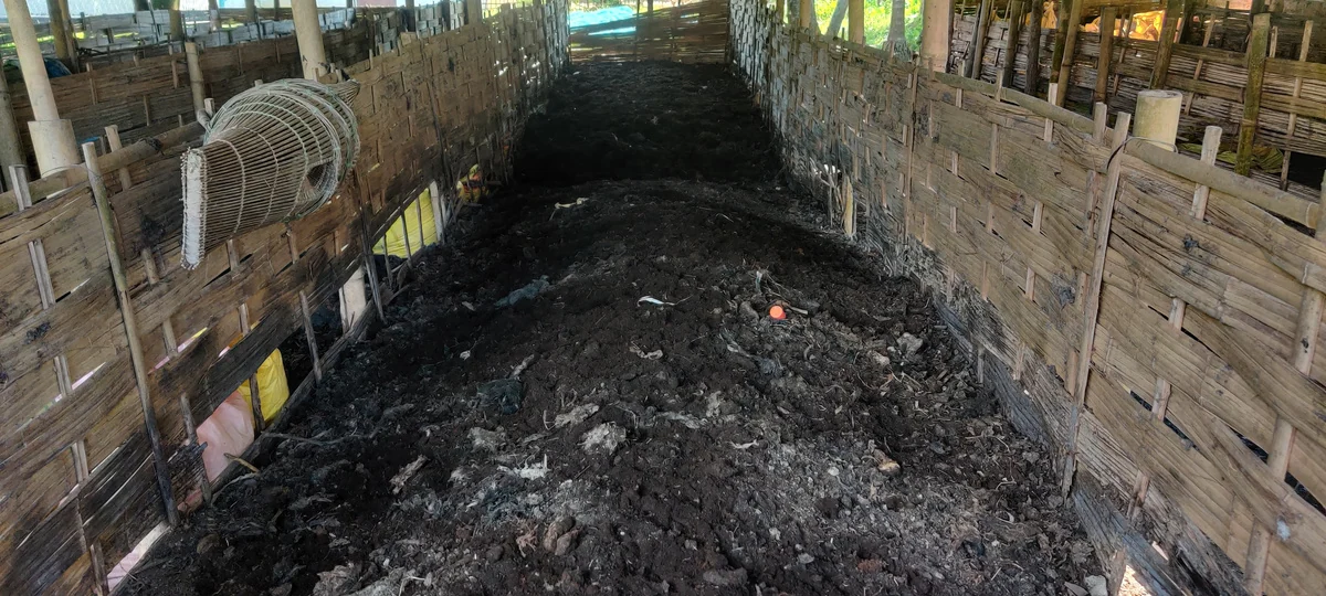 Compost heap prepared with cow dung and dry crop residues inside a shed